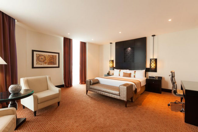 A bed, work desk and a seating area in hotel rooms close to the Emirates Mall